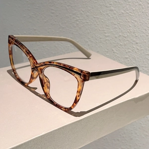 Side view of cat-eye eyewear frames with tortoiseshell front and contrast cream temples