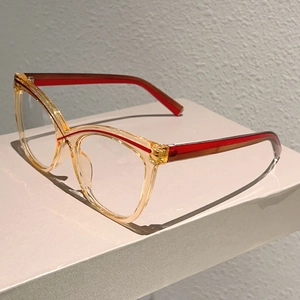 Detail view of cat eye glasses frame with amber finish and contrast red accents