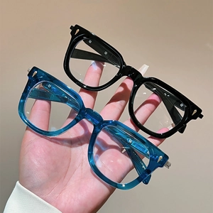 Cat eye metal frame blue light glasses in black and transparent blue shown in hand