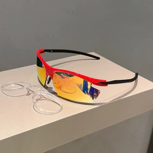 Detail of red sports sunglasses with golden mirrored lenses and transparent myopia frame