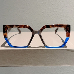 Detail of square oversized frames featuring brown tortoiseshell and blue contrast finish