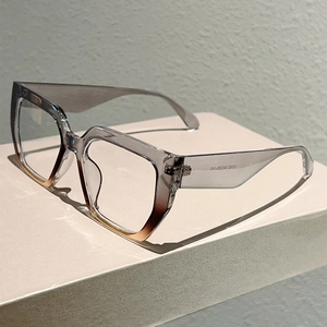 Retro square oversized glasses with gradient grey to amber frames on a minimalist stand