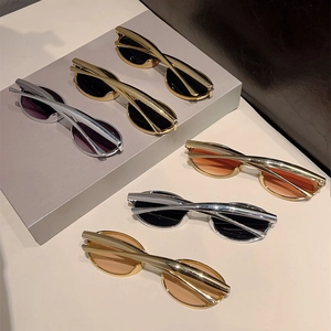 Détail des lunettes de soleil à monture croisée en métal avec verres ovales dorés