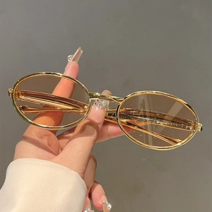 Gros plan sur des lunettes de soleil ovales vintage avec monture dorée et verres bruns