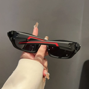 Detail of matte black sports sunglasses featuring dynamic red stripe design on the temples
