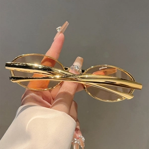 Gros plan sur des lunettes de soleil ovales vintage avec monture dorée et verres clairs