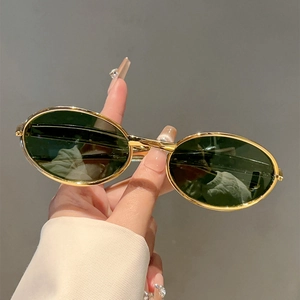 Gros plan de lunettes de soleil ovales rétro avec monture fine en métal doré et verres