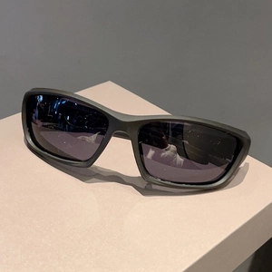 Detail of matte black wraparound sports sunglasses on a geometric display stand