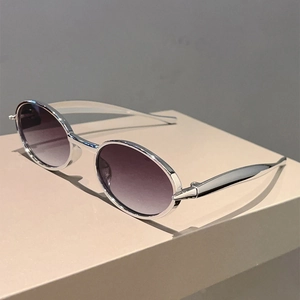 Vue latérale de lunettes de soleil ovales rétro avec monture argentée et verres dégradés