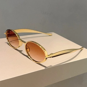 Détail de lunettes de soleil ovales vintage avec monture dorée et verres dégradés