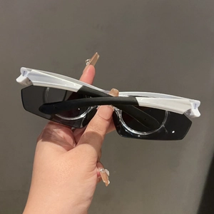 Close-up of black and white sport sunglasses featuring wide temples and dark lenses