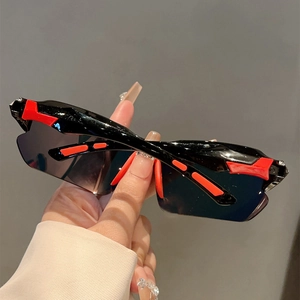 Detailed close-up of sporty black and red wraparound frame sunglasses with dark lenses