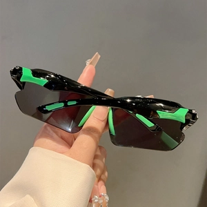 Detail of sleek black sports sunglasses with fluorescent green accents on the temple tips