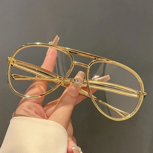Detailed close-up of retro gold metal aviator frames with clear lenses for a trendy look