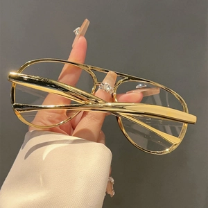 Detail of hand-held gold pilot style metal frames with double bridge and polished finish