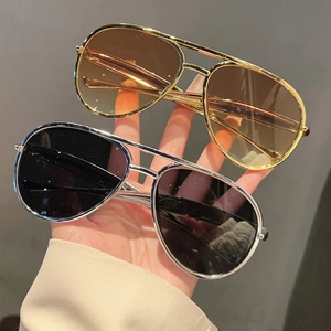 Close-up of classic aviator sunglasses with metal double bridge in gold and silver finishes