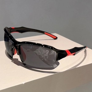 Close-up of black sports sunglasses with red non-slip temple pads on a grey stand