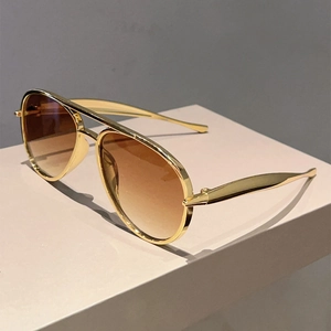 Detail of vintage aviator sunglasses with gold metal frame and brown gradient lenses