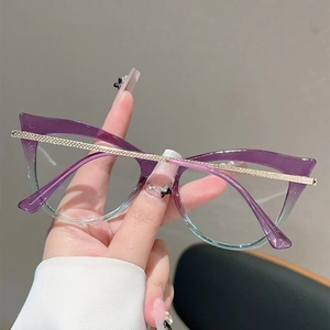 Detail of cat-eye glasses showing purple to teal gradient frame and gold metal temples