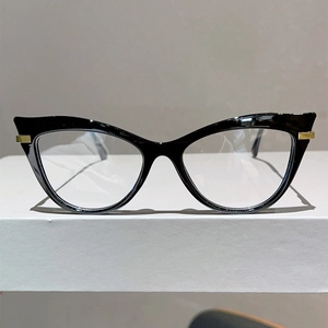 Close-up of black cat-eye glasses frame with elegant golden hinge detailing