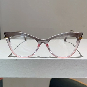 Close-up of cat-eye frames with gradient grey to pink finish and gold hinge detail