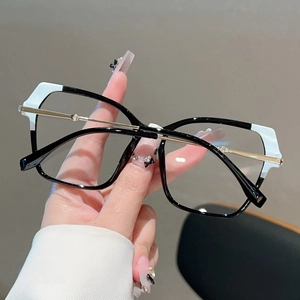 Detail of cat eye glasses with black and white color blocking and gold metal temples