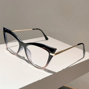 Detail of cat eye glasses frame with black to clear gradient and gold metal temples