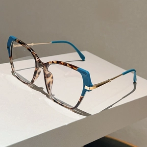 Detail of tortoiseshell cat-eye glasses frame with vibrant blue accents and gold temples