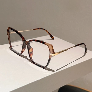 Detailed macro view of gold metal temples and tortoise shell tips on square glasses