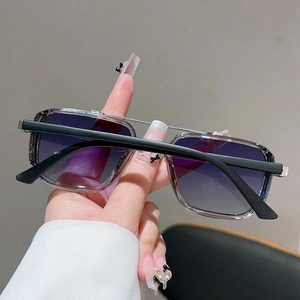 Détail de lunettes de soleil vintage carrées avec verres dégradés violets et double pont