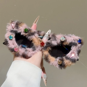 Détail d'une monture de lunettes léopard rose avec des strass colorés brillants