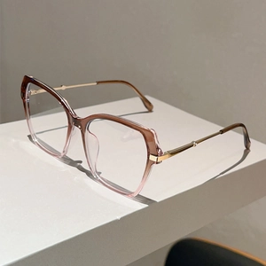 Detail of cat-eye gradient resin frames with golden metal temples and modern geometric design