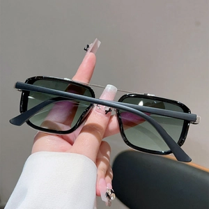 Détail de lunettes de soleil rétro avec double pont argenté et monture noire mate