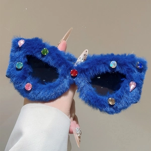 Détail de lunettes de soleil œil de chat en peluche bleu roi et cristaux colorés