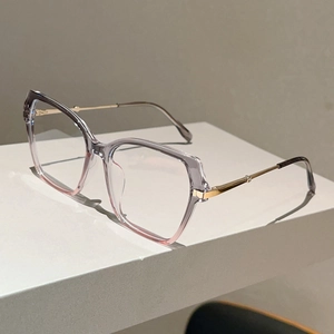 Detail of gradient grey and pink cat-eye frame with elegant gold metal temples