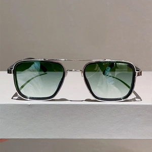 Détail de lunettes de soleil carrées en métal avec double pont et verres dégradés verts
