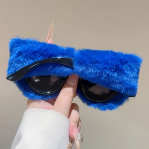 Détail de lunettes de soleil œil de chat en peluche bleue avec strass brillants