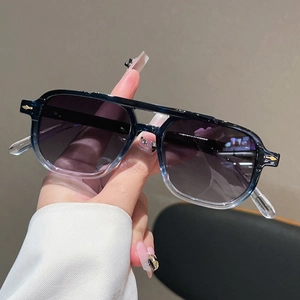 Détail de lunettes de soleil aviateur avec monture dégradée bleue et rivets dorés