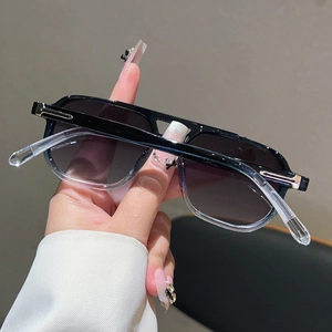 Gros plan de lunettes de soleil carrées rétro avec verres dégradés et détails argentés