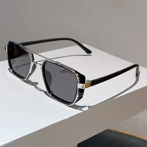 Détail de lunettes de soleil carrées noires avec double pont argenté sur support