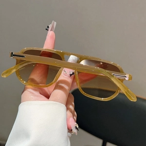Gros plan de lunettes aviateur écaillées avec verres dégradés et détail métallique en forme de T