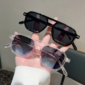 Détail de lunettes de soleil rétro à double pont avec charnières dorées en flèche