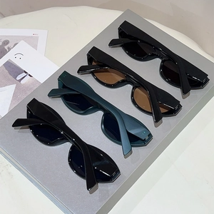 Close-up of four vintage cat-eye sunglasses in various colors on a display stand
