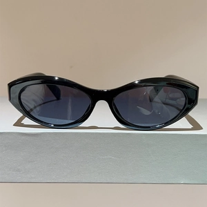 Detailed view of vintage oval sunglasses featuring glossy black frames and dark lenses