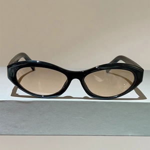 Detail view of vintage cat-eye sunglasses with thick black frames and amber tinted lenses