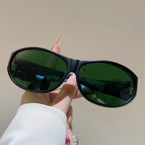 Détail de lunettes de cyclisme noir mat avec verres ovales vert foncé pour le sport