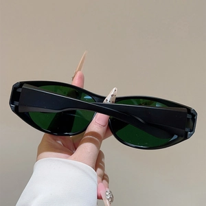 Détail de lunettes de soleil sport noires avec verres vert foncé et protection UV
