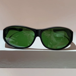 Détail des lunettes de cyclisme enveloppantes avec monture noire et verres vert foncé