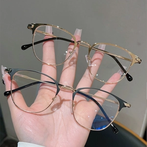 Detail of retro semi-rimless metal glasses frames in gold and black gold finishes