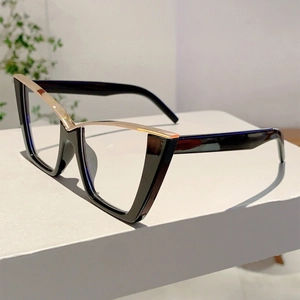 Detail of cat eye glasses frame showing black gloss finish and gold metal accents